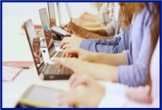 A picture showing typing on laptops in a classroom