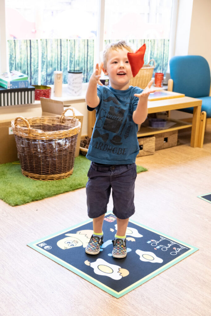 An image of an EYFS pupil standing on an Action Mat