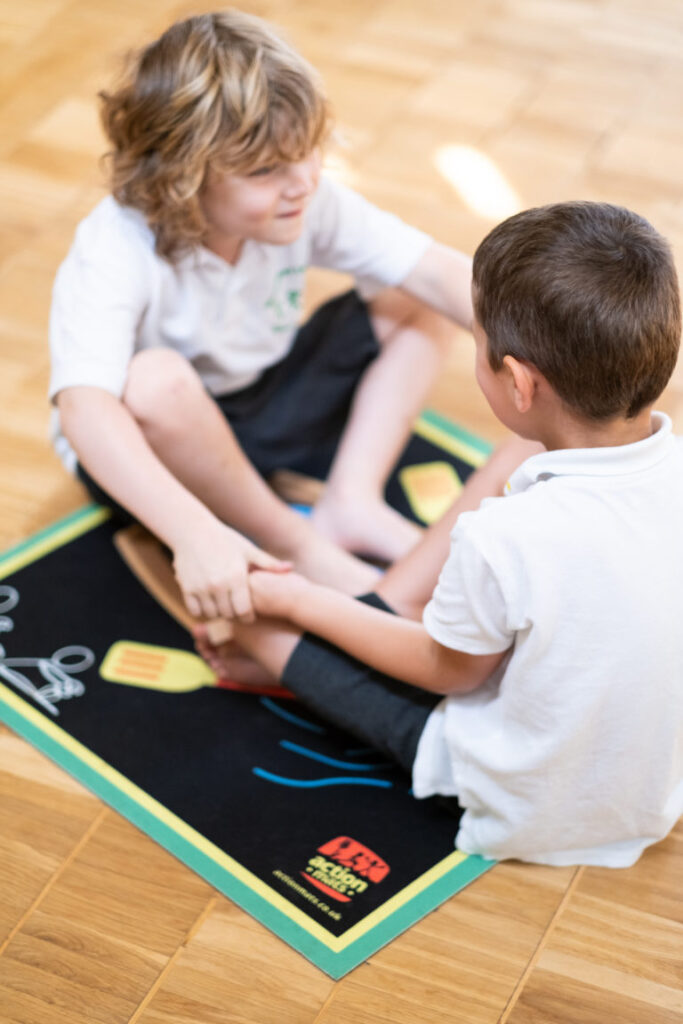 An image of two pupils sitting on an Action Mat