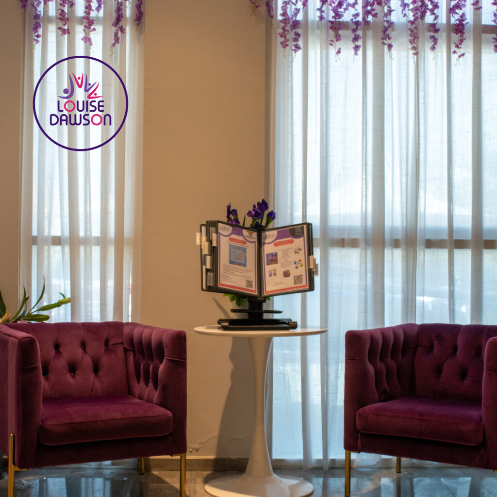 A quiet, welcoming seating area with purple chairs and information display at the KHDA-permitted Louise Dawson training centre, Dubai.