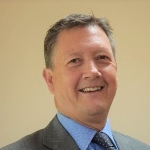 A headshot of the handsome and debonair Mr Bill Turner of Search Associates. Bill is laughing, showing how happy, friendly, and approachable he is.